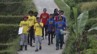 Para peserta berjalan menuju lokasi kompetisi Water Adventure Jelajah Air Nusantara di Desa Ciasihan, Kecamatan Pamijahan, Kabupaten Bogor, Jawa Barat, Kamis (9/12/2021). [Suara.com/Angga Budhiyanto]