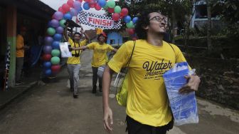 Tim dari Gilang Bhaskara berlari melewati garis finish saat mengikuti kompetisi Water Adventure Jelajah Air Nusantara di Desa Ciasihan, Kecamatan Pamijahan, Kabupaten Bogor, Jawa Barat, Kamis (9/12/2021). [Suara.com/Angga Budhiyanto]