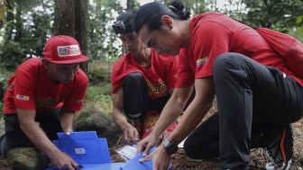 Tim dari Rikas Harsa berusaha menyelesaikan tantangan dalam kompetisi Water Adventure Jelajah Air Nusantara di Desa Ciasihan, Kecamatan Pamijahan, Kabupaten Bogor, Jawa Barat, Kamis (9/12/2021). [Suara.com/Angga Budhiyanto]