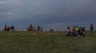 Warga menyaksikan matahari tenggelam saat mengunjungi kawasan Pantai Maju, Pantai Indah Kapuk (PIK), Kamal Muara, Jakarta, Sabtu (11/12/2021). ANTARA FOTO/Wahyu Putro 