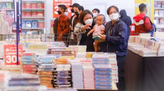 Pengunjung memilih buku dalam pameran Indonesia Internationa Book Fair (IIBF) 2021 di JCC Senayan, Jakarta Pusat, Minggu (12/12/2021). [Suara.com/Alfian Winanto]