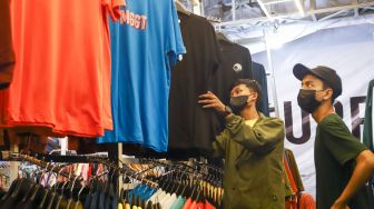 Pengunjung memilih pakaian di event Jakarta Clothing (JakCloth) 2021 di JCC Senayan, Jakarta Pusat, Minggu (12/12/2021). [Suara.com/Alfian Winanto]