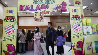 Pengunjung usai mengunjungi pameran Indonesia Internationa Book Fair (IIBF) 2021 di JCC Senayan, Jakarta Pusat, Minggu (12/12/2021). [Suara.com/Alfian Winanto]
