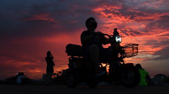 Warga menyaksikan matahari tenggelam saat mengunjungi kawasan Pantai Maju, Pantai Indah Kapuk (PIK), Kamal Muara, Jakarta, Sabtu (11/12/2021). ANTARA FOTO/Wahyu Putro 