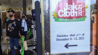 Pengunjung usai belanja pakaian di event Jakarta Clothing (JakCloth) 2021 di JCC Senayan, Jakarta Pusat, Minggu (12/12/2021). [Suara.com/Alfian Winanto]