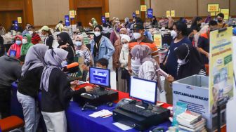 Antrian pengunjung yang membeli buku di pameran Indonesia Internationa Book Fair (IIBF) 2021 di JCC Senayan, Jakarta Pusat, Minggu (12/12/2021). [Suara.com/Alfian Winanto]