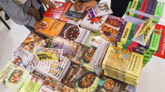 Pengunjung memilih buku dalam pameran Indonesia Internationa Book Fair (IIBF) 2021 di JCC Senayan, Jakarta Pusat, Minggu (12/12/2021). [Suara.com/Alfian Winanto]