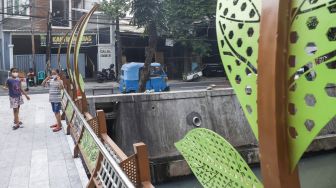 Anak-anak melintasi jembatan di Jalan Galur Sari Timur, Matraman, Jakarta Timur, Senin (13/12/2021). [Suara.com/Alfian Winanto]