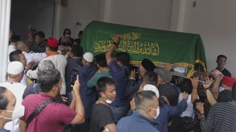 Keluarga dan kerabat mengusung peti jenazah almarhum politikus senior Abraham Lunggana atau Haji Lulung setibanya di rumah duka di kawasan Sukabumi Utara, Kebon Jeruk, Jakarta, Selasa (14/12/2021). [Suara.com/Angga Budhiyanto]