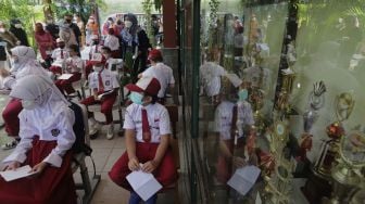 Sejumlah pelajar menunggu untuk mendapatkan vaksin COVID-19 di SDN 04 Cilandak Barat, Jakarta, Selasa (14/12/2021). [Suara.com/Angga Budhiyanto]