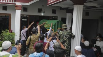 Keluarga dan kerabat mengusung peti jenazah almarhum politikus senior Abraham Lunggana atau Haji Lulung setibanya di rumah duka di kawasan Sukabumi Utara, Kebon Jeruk, Jakarta, Selasa (14/12/2021). [Suara.com/Angga Budhiyanto]