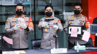 Polisi menunjukkan barang bukti saat rilis kasus perampokan toko gadai di Polres Metro Jakarta Selatan, Selasa (14/12/2021). [Suara.com/Alfian Winanto]