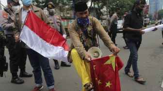 Massa yang tergabung dalam Forum Cinta Tanah Air membawa bendera China saat melakukan aksi unjuk rasa di depan Kedubes Republik Rakyat China (RRC), Jakarta, Rabu (15/12/2021). [Suara.com/Angga Budhiyanto]