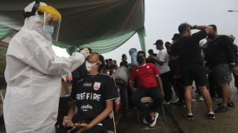 Tenaga kesehatan melakukan tes usap antigen kepada suporter yang akan memasuki Stadion Pakansari, Cibinong, Kabupaten Bogor, Jawa Barat, Rabu (15/12/2021). [Suara.com/Angga Budhiyanto]