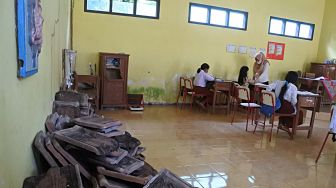 Siswa SDN 01 Alasbayur belajar di ruang kelas yang rusak di Desa Alasbayur, Mlandingan, Situbondo, Jawa Timur, Rabu (15/12/2021). ANTARA FOTO/Seno