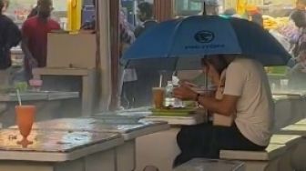 Serasa Dunia Milik Berdua, Pasangan Ini Jadi Perhatian Karena Makan Sambil Hujan-Hujanan