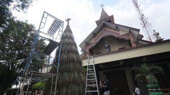 Petugas gereja memberi corak warna pada sapu lidi dengan cat saat membuat pohon Natal di Gereja Katolik Santa Perawan Maria Bunda Kristus, Wedi, Klaten, Jawa Tengah, Sabtu (18/12/2021).  ANTARA FOTO/Aloysius Jarot Nugroho