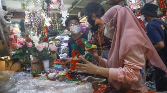 Pengunjung memilih barang pernak-pernik Natal di Pasar Asemka, Jakarta Barat, Sabtu (18/12/2021). [Suara.com/Alfian Winanto]