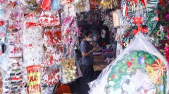 Pengunjung memilih pernak-pernik Natal di Pasar Asemka, Jakarta Barat, Sabtu (18/12/2021). [Suara.com/Alfian Winanto]