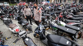 Kapolresta Sidoarjo Kombes Pol Kusumo Wahyu Bintoro (kanan) Kasatlantas Polresta Sidoarjo AKP Yanto Mulyanto melihat ratusan kendaraan bermotor milik warga yang terjaring razia di halaman Polresta Sidoarjo, Jawa Timur, Sabtu (18/12/2021).  ANTARA FOTO/Umarul Faruq