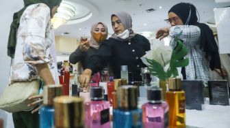 Pengunjung memilih parfum di acara Muslima Festival 2021 di Smesco Indonesia, Jakarta Selatan, Sabtu (18/12/2021). [Suara.com/Alfian Winanto]