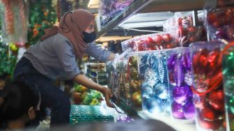 Pengunjung memilih barang pernak-pernik Natal di Pasar Asemka, Jakarta Barat, Sabtu (18/12/2021). [Suara.com/Alfian Winanto]