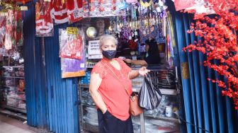 Pengunjung memilih pernak-pernik Natal di Pasar Asemka, Jakarta Barat, Sabtu (18/12/2021). [Suara.com/Alfian Winanto]