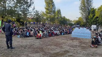 Pengungsi dari Myanmar yang melarikan diri dari gelombang kekerasan duduk dalam antrean saat mereka diproses di Mae Tao Phae, distrik Mae Sot, Thailand, pada (16/12/2021). [HANDOUT / METTA CHARITY / AFP]