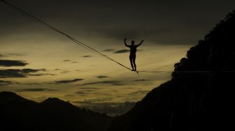 Pegiat olahraga ekstrem berjalan di atas tali webbing pada kegiatan Bandung Highlines Festival di Tebing Hawu, Kabupaten Bandung Barat, Sabtu (18/12/2021). [ANTARA FOTO/Novrian Arbi]