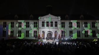 Sejumlah pengunjung melihat video mapping bernuansa Natal yang ditampilkan dalam acara 'Christmas in Jakarta' di Museum Fatahillah, Kota Tua, Jakarta, Minggu (19/12/2021). [Suara.com/Angga Budhiyanto]