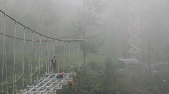 Sejumlah pekerja memasang kerangka besi saat membangun jembatan gantung di lereng Gunung Merapi, Tegalmulyo, Kemalang, Klaten, Jawa Tengah, Sabtu (18/12/2021). [ANTARA FOTO/Aloysius Jarot Nugroho]