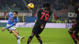 Pemain depan Napoli Hirving Lozano (kiri) melepaskan tembakan selama pertandingan sepak bola Serie A Italia antara AC Milan dan Napoli di stadion San Siro, Milan, pada (19/12/2021). [MIGUEL MEDINA / AFP]