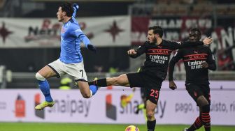 Gelandang Napoli Eljif Elmas (kiri) dan gelandang AC Milan Alessandro Florenzi berebut bola selama pertandingan sepak bola Serie A Italia antara AC Milan dan Napoli di stadion San Siro, Milan, pada (19/12/2021). [MIGUEL MEDINA / AFP]