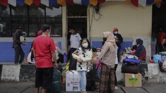 Sejumlah calon penumpang menunggu kedatangan bus di Terminal Kampung Rambutan, Jakarta, Selasa (21/12/2021). [Suara.com/Angga Budhiyanto]