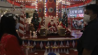 Santa Claus duduk di area dekorasi Natal di Central Park Mall, Jakarta, Selasa (21/12/2021). [Suara.com/Angga Budhiyanto]