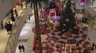 Pengunjung berjalan di dekat dekorasi Natal di Central Park Mall, Jakarta, Selasa (21/12/2021). [Suara.com/Angga Budhiyanto]