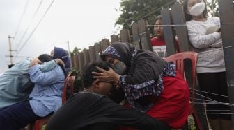 Dua orang ibu memeluk anaknya usai mengikuti acara Cuci Kaki Ibu Massal di Kelurahan Duri Pulo, Gambir, Jakarta, Rabu (22/12/2021). [Suara.com/Angga Budhiyanto]