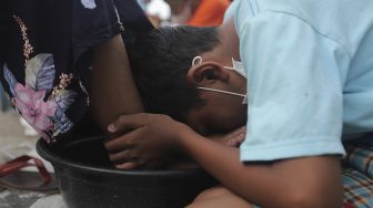 Seorang anak mencium kaki ibunya saat acara Cuci Kaki Ibu Massal di Kelurahan Duri Pulo, Gambir, Jakarta, Rabu (22/12/2021). [Suara.com/Angga Budhiyanto]