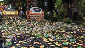 Kapolda Banten Irjen Pol Rudy Heriyanto (kedua kiri) bersama jajaran Forkompimda mengoperasikan alat berat saat pemusnahan ribuan botol minuman keras (miras) ilegal di Serang, Banten, Kamis (23/12/2021). ANTARA FOTO/Asep Fathulrahman