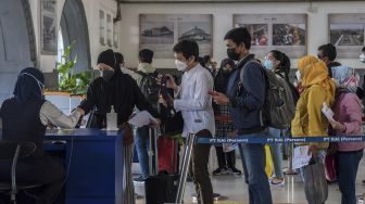 Penumpang antre untuk memasuki area peron di Stasiun Pasar Senen, Jakarta, Jumat (24/12/2021).  ANTARA FOTO/Galih Pradipta
