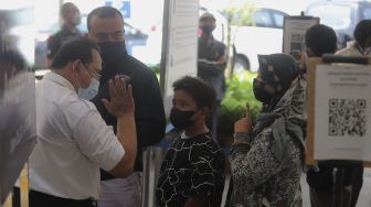 Petugas memberi arahan kepada calon penumpang yang akan melakukan tes usap antigen dan PCR di Stasiun Pasar Senen, Jakarta, Jumat (24/12/2021). [Suara.com/Angga Budhiyanto]