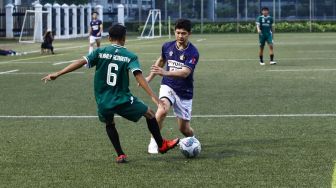 Aksi Aktor Iko Uwais bermain sepak bola saat laga persahabatan antara Selebritis FC vs AIFC Garuda Putih di Lapangan ABC Senayan, Jakarta Pusat, Jumat (24/12/2021). [Suara.com/Alfian Winanto]