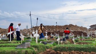 Warga datang untuk ziarah di makam keluarganya di TPU Rorotan, Jakarta Utara, Sabtu (25/12/2021). [Suara.com/Alfian Winanto]