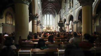 Suasana umat Kristiani saat mengikuti Misa Natal di Gereja Katedral, Jakarta Pusat, Sabtu (25/12/2021). [Suara.com/Alfian Winanto,]