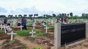 Suasana warga berziarah di TPU Rorotan, Jakarta Utara, Sabtu (25/12/2021). [Suara.com/Alfian Winanto]