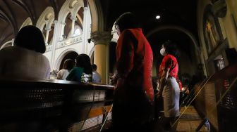 Umat Kristiani berdoa saat mengikuti Misa Natal di Gereja Katedral, Jakarta Pusat, Sabtu (25/12/2021). [Suara.com/Alfian Winanto,]