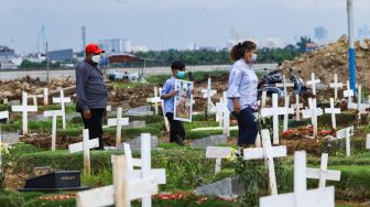 Warga datang untuk ziarah di makam keluarganya di TPU Rorotan, Jakarta Utara, Sabtu (25/12/2021). [Suara.com/Alfian Winanto]