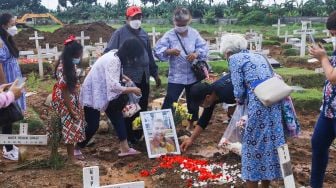 Warga ziarah di makam keluarganya di TPU Rorotan, Jakarta Utara, Sabtu (25/12/2021). [Suara.com/Alfian Winanto]