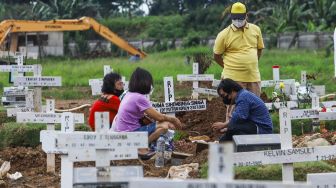 Warga ziarah di makam keluarganya di TPU Rorotan, Jakarta Utara, Sabtu (25/12/2021). [Suara.com/Alfian Winanto]