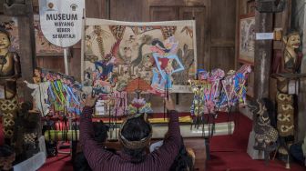 Dalang Indra Suroinggeno (tengah) memainkan wayang kulit bertema Natal di Bantul, Yogyakarta, pada (24/12/2021). [AGUNG SUPRIYANTO / AFP]